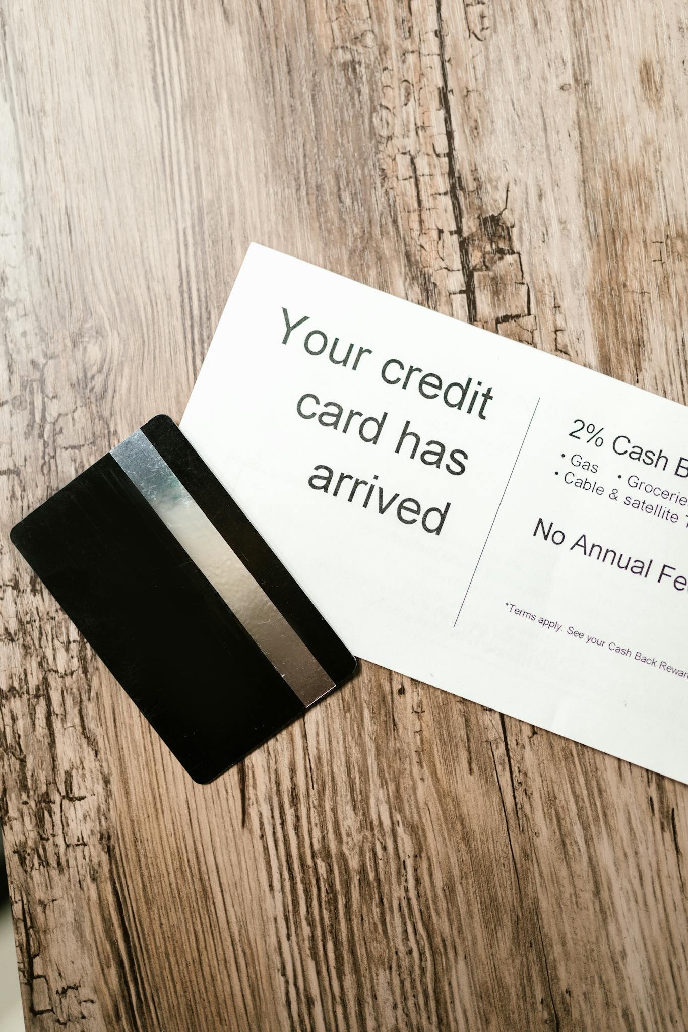 Home 2 Close-up view of a credit card and welcome letter on a wooden table, emphasizing finance and banking.