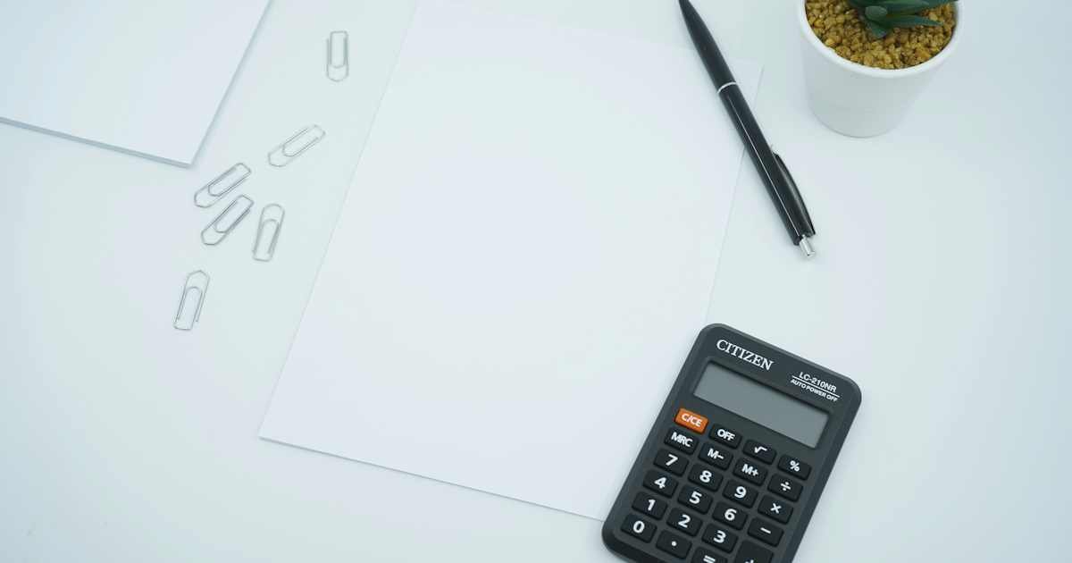 Calculator, pen, and papers on a desk for reviewing card payment amounts