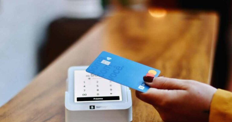 Customer holding a credit card near a contactless payment terminal
