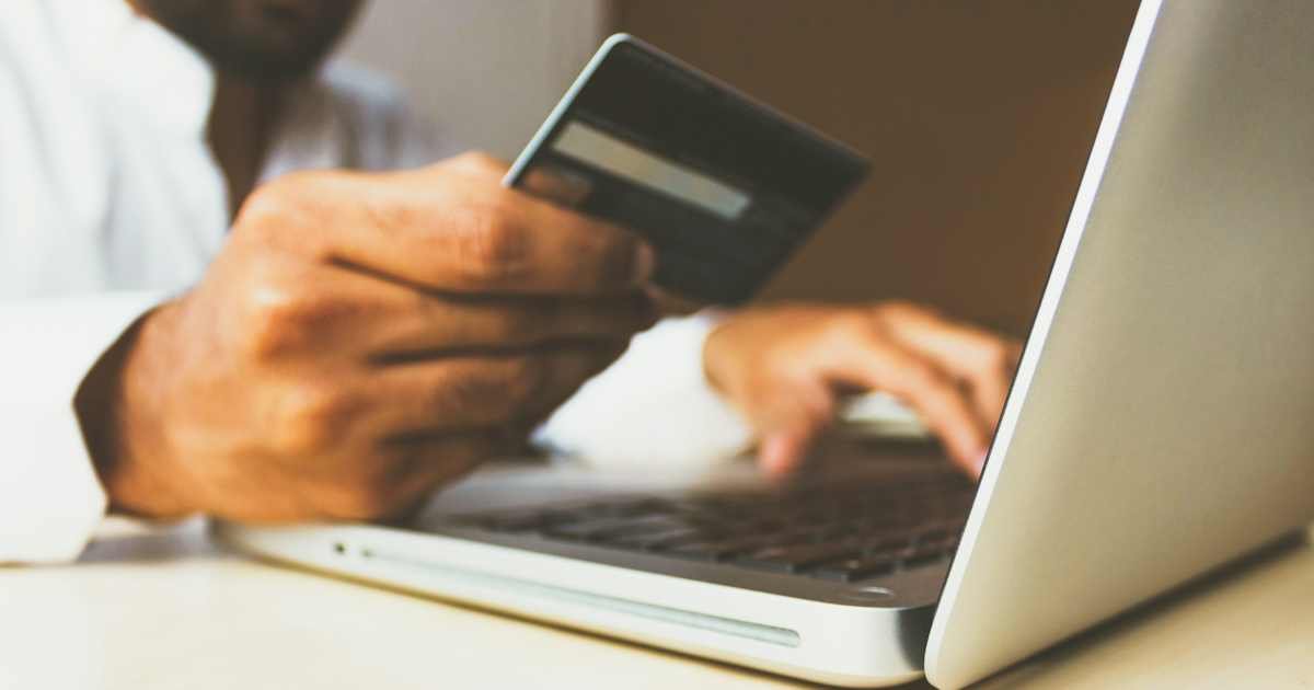 Person checking an online payment with a credit card and laptop