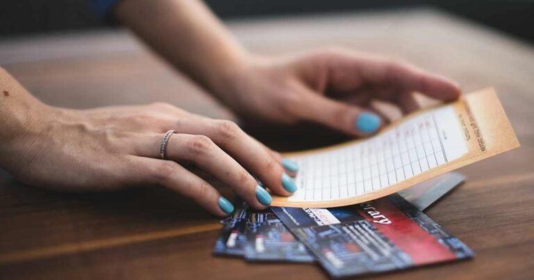 Person reviewing a payment card with transaction receipts