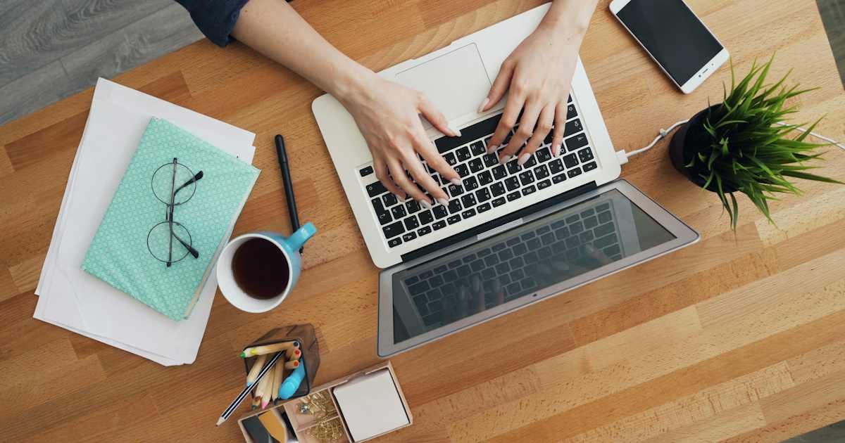 Person typing on a laptop in a home office representing a writing software subscription